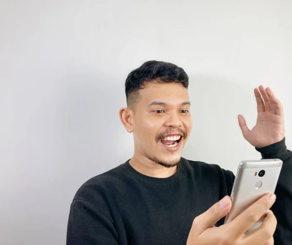 Genç Asyalı Bir Adam Akıllı Telefona Bakarken Gülümsüyor — Stok fotoğraf