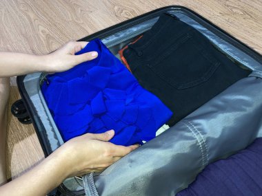 Evde bavul hazırlayan bir kadın. Seyahat kavramı