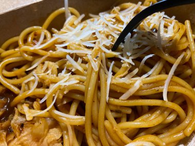 Close up selective focus on spaghetti bolognese with cheese
