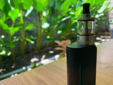 vaporizer or e-cigarette device with plants background