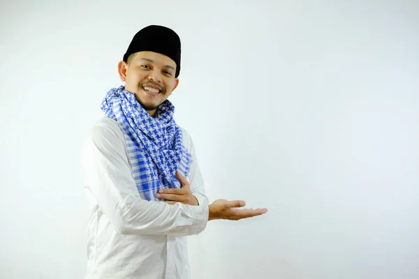 一个头戴帽子 面带微笑的年轻穆斯林 举起手 做了些什么 做了个欢迎的手势 — 图库照片