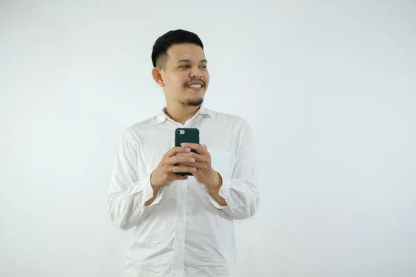 Yetişkin Asyalı Adam Cep Telefonunu Tutarken Gülümsüyor Sağ Tarafına Bakıyor — Stok fotoğraf