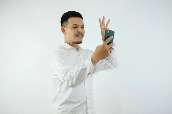 Yakışıklı Asyalı Rahat Gömlekli Akıllı Telefon Tutan Parmağıyla Işaret Eden — Stok fotoğraf