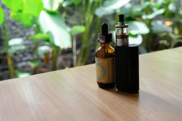 stock image vape and e-cigarette liquid on wooden table