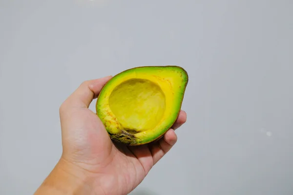 Hand Mit Halbierter Avocado Auf Grauem Hintergrund — Stockfoto
