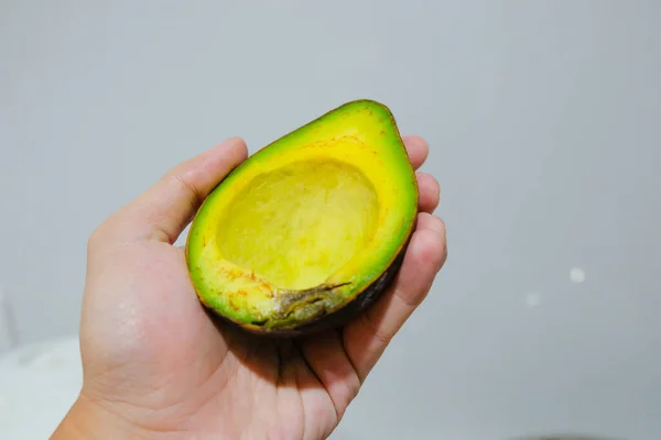 Hand Houden Avocado Gesneden Helft Grijze Achtergrond — Stockfoto