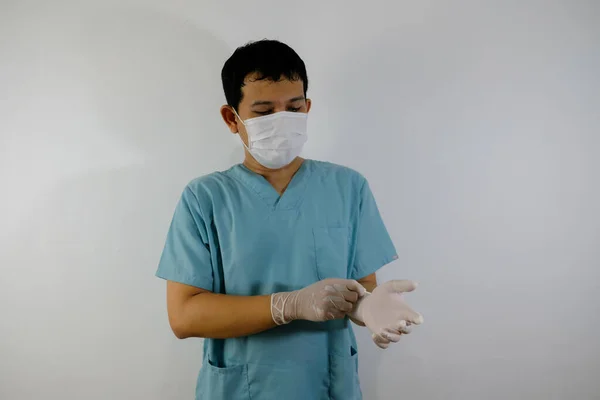 准备动手术外科医生戴着外科手套站在灰色背景下的特写镜头 — 图库照片