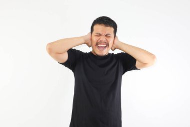 Yetişkin Asyalı adam çaresizce bağırırken eliyle kulaklarını kapatıyor.