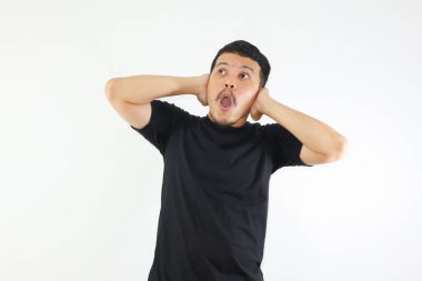 Asyalı bir adam şok olmuş yüzünü gösteriyor ve yukarı bakıyor.