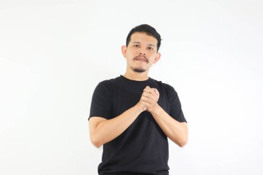 Genç Asyalı bir adam ellerini kenetledi ve sakin bir ifade sergiledi.