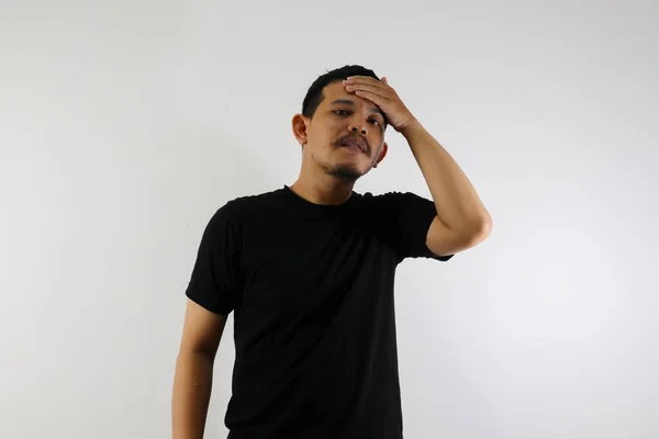 stock image Asian man wearing black shirt, looking stressed expression and touching his forehead