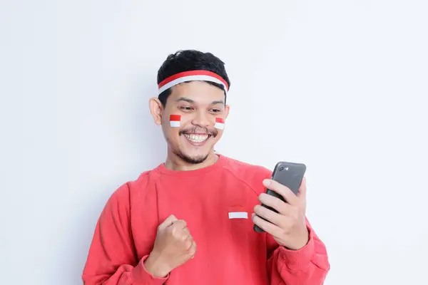 Pria Indonesia Tersenyum Sambil Memegang Ponsel Selama Perayaan Hari Kemerdekaan — Stok Foto