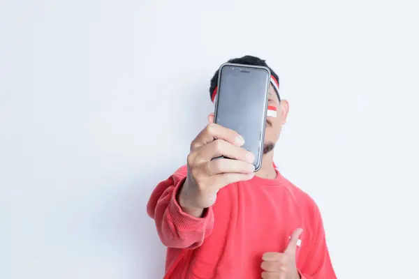 Endonezyalı Adam Gülümseyip Başparmak Kaldırırken Bağımsızlık Gününde Elinde Cep Telefonu — Stok fotoğraf