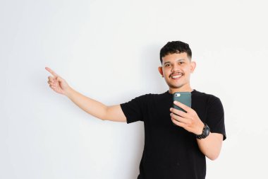 Asyalı bir adam akıllı telefonunu tutarken bir yönü işaret eder.