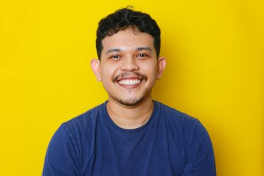 Asyalı genç bir adamın izole edilmiş bir şekilde gülümsemesi, stüdyo çekimi. reklam kavramı.