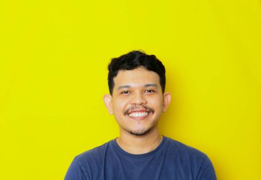 Asyalı genç bir adamın izole edilmiş bir şekilde gülümsemesi, stüdyo çekimi. reklam kavramı.