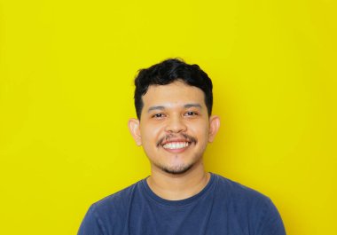 Asyalı genç bir adamın izole edilmiş bir şekilde gülümsemesi, stüdyo çekimi. reklam kavramı.
