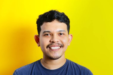 Asyalı genç bir adamın izole edilmiş bir şekilde gülümsemesi, stüdyo çekimi. reklam kavramı.