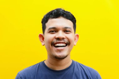 Asyalı genç bir adamın izole edilmiş bir şekilde gülümsemesi, stüdyo çekimi. reklam kavramı.