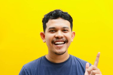 Asyalı genç bir adamın portresi mutlu bir ifadeyle, stüdyo çekimi