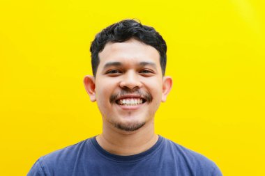 Asyalı genç bir adamın izole edilmiş bir şekilde gülümsemesi, stüdyo çekimi. reklam kavramı.