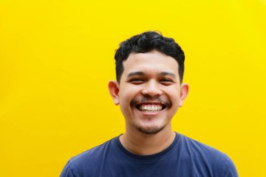 Asyalı genç bir adamın izole edilmiş bir şekilde gülümsemesi, stüdyo çekimi. reklam kavramı.