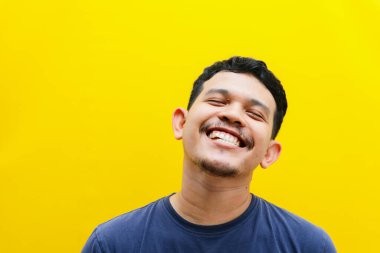 Asyalı genç bir adamın izole edilmiş bir şekilde gülümsemesi, stüdyo çekimi. reklam kavramı.