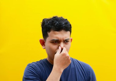 Burnunu kapatan Asyalı genç bir adamın portresi. Stüdyo çekimi