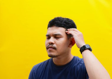 Çok düşünen Asyalı genç bir adamın portresi. Stüdyo çekimi