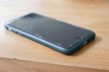 Ahşap arka planda bir akıllı telefon.