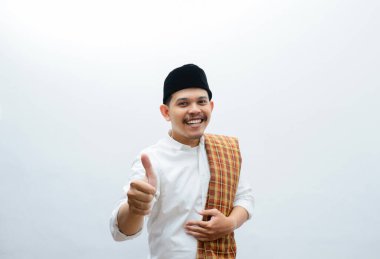 Asyalı Müslüman adam mutlu bir ifadeyle baş parmağını kaldırıyor.