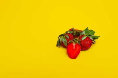 Sarı arka planda izole edilmiş çilek fotoğrafı