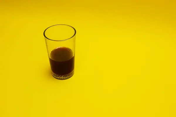 a glass of coffee isolated on yellow background
