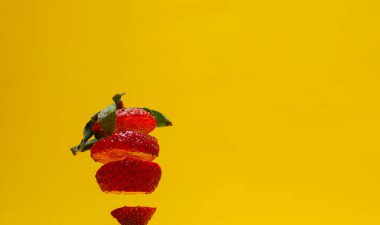 Sarı arka planda izole edilmiş çilek fotoğrafı