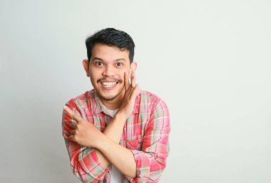 Komik Asyalı adam beyaz arka planda gizli bir dedikodu fısıldıyor..