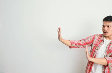 Asyalı bir adam ya ret işareti gösterir ya da göstermez.