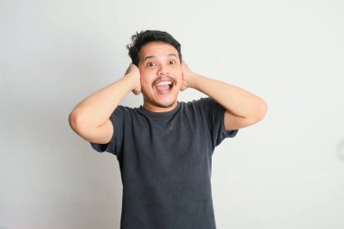 Kafasını tutan mutlu Asyalı adam ifadesi