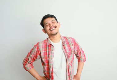 Asyalı genç adam rahatlamış ve gülümsüyor.