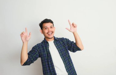 Asyalı bir adam gülümser ve eliyle bir şeye işaret eder, reklam kavramları.