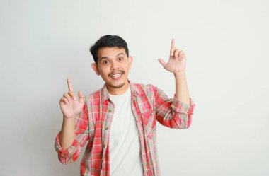 Asyalı bir adam gülümser ve eliyle bir şeye işaret eder, reklam kavramları.