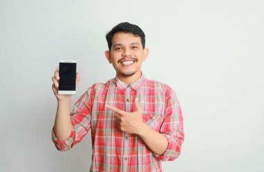 Gri arka planda Asyalı bir adamın telefon tutarken görüntüsü. reklam kavramı.