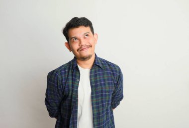 Beyaz duvarda izole edilmiş sıradan gömlekli Asyalı bir adamın komik gülüşü..