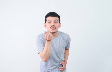 Asyalı bir adam mutlu bir ifade ve sevgi jesti gösterir.