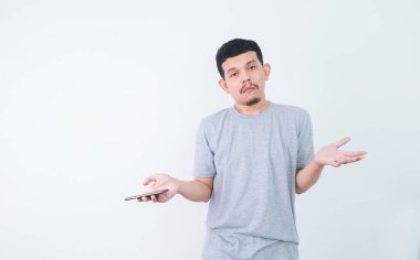 Üzgün Asyalı adamın internette kötü haberleri var ve akıllı telefondan hayal kırıklığına uğruyor..