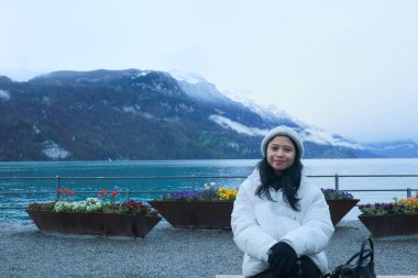 Brienz Gölü kıyısında bir kadın oturuyor, İsviçre