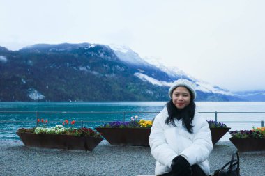 Brienz Gölü kıyısında bir kadın oturuyor, İsviçre