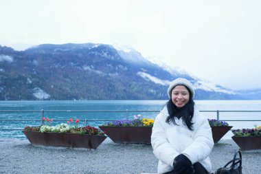 Brienz Gölü kıyısında bir kadın oturuyor, İsviçre