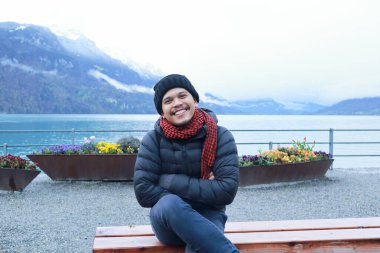 Brienz Gölü kıyısında bir adam oturuyor, İsviçre