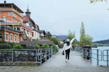 Kış kıyafetleri giyen Asyalı bir kadın, Brienz İsviçre 'nin manzarasının tadını çıkarıyor.