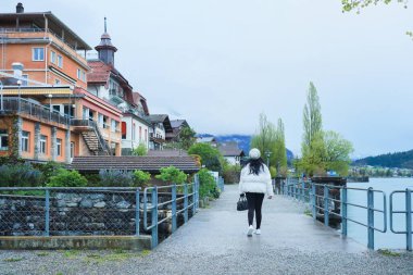 Kış kıyafetleri giyen Asyalı bir kadın, Brienz İsviçre 'nin manzarasının tadını çıkarıyor.